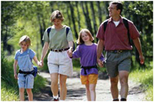 Family of four walking on a path in the woods.