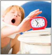 Yawning woman reaching for alarm clock sitting on table